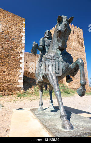 Eine Reiterstatue von Ibn Qasi, der Proklamierten politischen und geistigen Führer der taifa Königreich mertola, mit dem Turm von Schloss Mertola Stockfoto