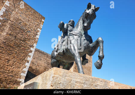 Eine Reiterstatue von Ibn Qasi, der Proklamierten politischen und geistigen Führer der taifa Königreich mertola, mit dem Turm von Schloss Mertola Stockfoto