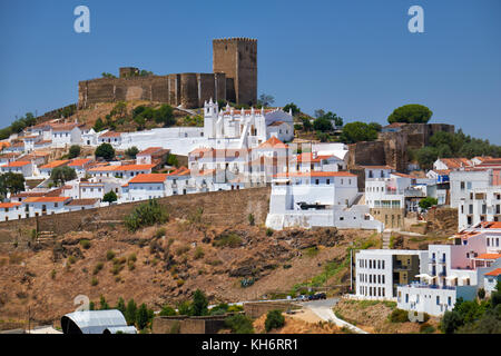 Die mittelalterliche Burg auf dem Gipfel des Hügels von Wohn- Alentejo Land umgeben - style Häuser innerhalb der alten Stadtmauern von Mértola. Stockfoto