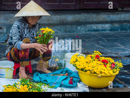 Vietnamesin, die Blumen in einem Markt, in Hoi An Vietnam Stockfoto