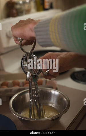 Nahaufnahme der mans hand rühren, Ei in Küche Stockfoto