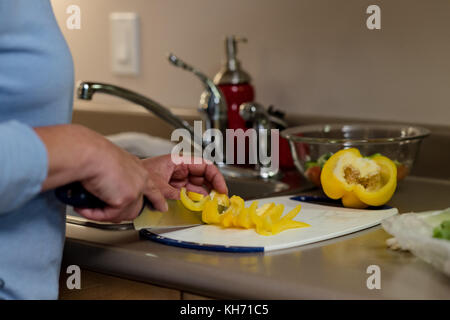 Ältere Frau Schneiden von Gemüse in der Küche zu Hause. Stockfoto