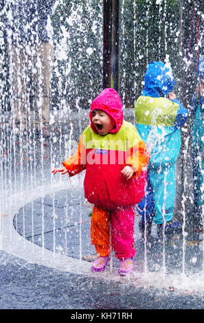 Kinder spielen in einem Wasserspiel in den Alnwick Gardens. Stockfoto