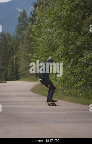 Ansicht der Rückseite des skateboarder Skaten auf der Straße Stockfoto