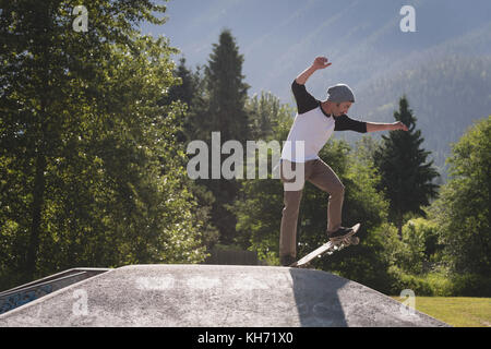 Skateboarder Durchführung stunt auf der Rampe in Skate Park Stockfoto