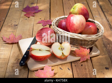 In Scheiben geschnitten Apple mit anderen ganze Äpfel auf einer hölzernen Oberfläche Stockfoto