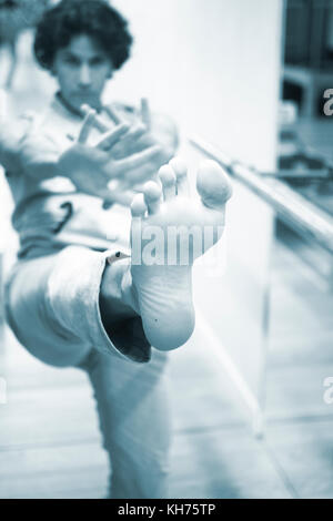 Man Tänzer Tanz Lehrer stetching in Fitnesscenter Fitness Studio, erweiterte Bar dehnen Flexibilität Körperhaltung. Stockfoto