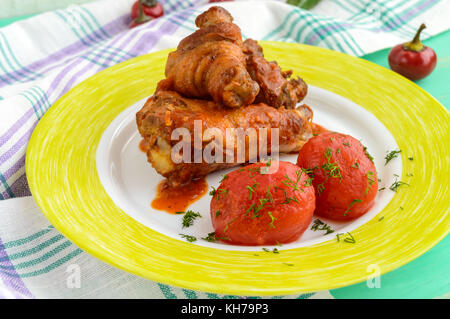 Hähnchenschenkel mit Tomatensauce und marinierten Tomaten ohne Skins im eigenen Saft. Stockfoto