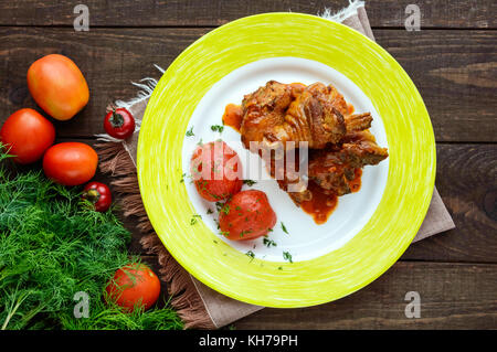 Hähnchenschenkel mit Tomatensauce und marinierten Tomaten ohne Skins im eigenen Saft. die Ansicht von oben. Stockfoto