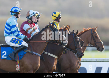 Jockeys und Pferde bereiten Sie ein Rennen auf Ffos Las, Trimsaran, Carmarthenshire, Wales tragen helle, farbenfrohe racing Farben zu Start/racing Seide Stockfoto