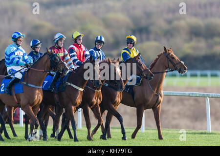 Jockeys und Pferde bereiten Sie ein Rennen auf Ffos Las, Trimsaran, Carmarthenshire, Wales tragen helle, farbenfrohe racing Farben zu Start/racing Seide Stockfoto