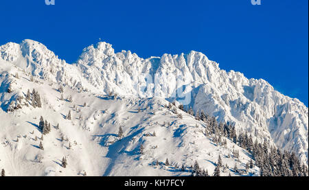 Hohe Berge mit Gipfelkreuz unter tiefen Schnee im Winter. rauhhorn, Allgäu, Bayern in Deutschland. Stockfoto