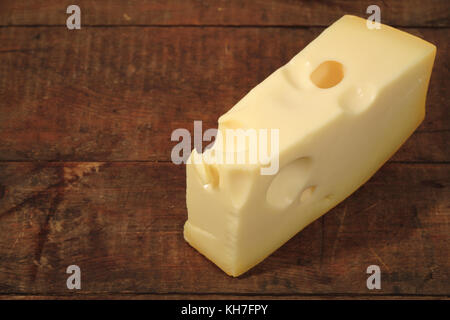 Ein Stück Käse liegen auf Holz- Hintergrund mit Kopie Raum Stockfoto