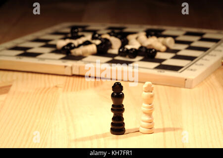 Schach Konzept. zwei schachfiguren in der Nähe von Schachbrett auf hölzernen Hintergrund Stockfoto