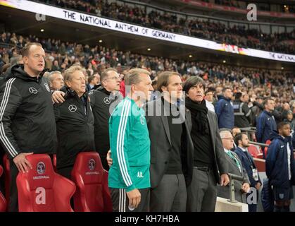 V.r. Trainer/ Bundestrainer Joachim 'Jogi' LOEW (LOW) (GER), Thomas SCHNEIDER (Co-Trainer/ Assistenztrainer, GER), Andreas KOEPKE (Kopke, Torwartcoach, GER), Mannschaftsarzt Dr. Tim MEYER (DE), Physiotherapeut Klaus EDER, Mannschaftsarzt Dr. Jochen HAHNE (DE), singen die Hymne, Nationalhymne, Fussball Laenderspiel, Freundschaftsspiel, England (eng) - Deutschland (DE) 0:0, am 10.11.2017 in London/Grossbritannien. |Nutzung weltweit Stockfoto