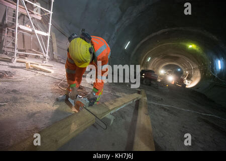 Stuttgart, Deutschland. November 2017. Ein Bauarbeiter schneidet im Tunnel Bad Cannstatt, der im Zuge des Eisenbahnprojekts Stuttgart 21 am 13. November 2017 in Stuttgart gebaut wird, einen Balken auf die Größe. Quelle: Marijan Murat/dpa/Alamy Live News Stockfoto