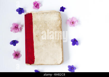 Alte Bücher und Blumen auf weißem Hintergrund Stockfoto