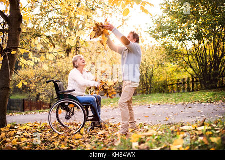 Senior Paar im Rollstuhl im Herbst Natur. Stockfoto