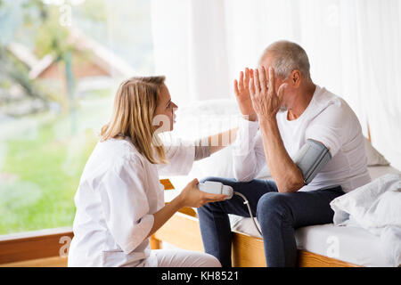 Gesundheit Besucher und ein älterer Mann im Hause besuchen. Stockfoto