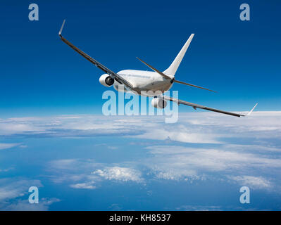 Weißen Passagier wide-body Ebene. Flugzeuge ist das Fliegen in blauen bewölkten Himmel über dem Meer. Stockfoto