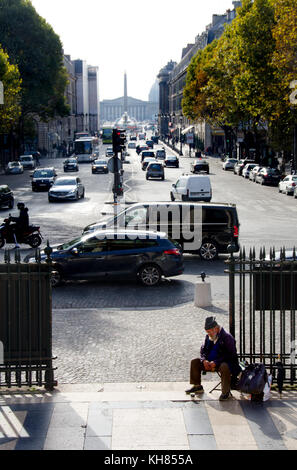 Paris, Frankreich. Obdachloser am Gate La Madelaine Kirche betteln, Place de La Madelaine - Place de la Concorde in der Ferne Stockfoto