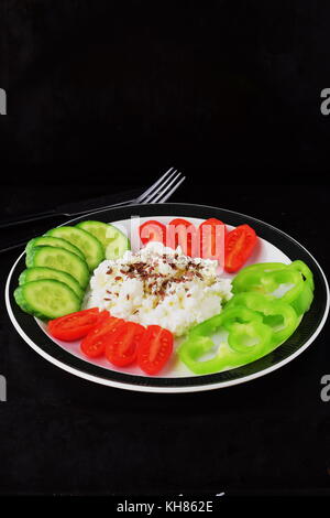 Einfaches Frühstück mit Paprika, Tomaten, Gurken mit Quark und Leinsamen auf einem Schild auf einem dunklen Hintergrund Gesunde Ernährung Gesunde Ernährung Konzept. Stockfoto