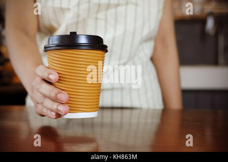 Close-up Kellnerin eine Tasse Kaffee serviert. Selektive konzentrieren. Stockfoto