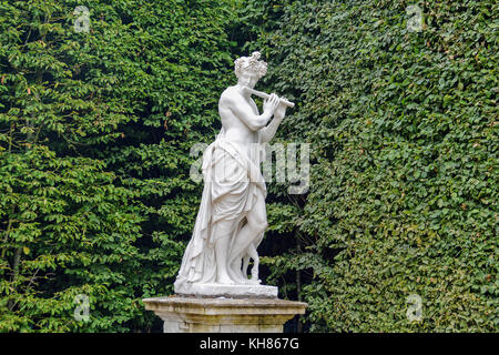 Flöte spielen Statue in der Kuppel Garten des Schlosses von Versailles, Versailles, Frankreich. Foto im Sommer 2014 übernommen. Stockfoto