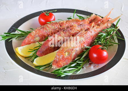 Gegrillte Rotbarbe in einem Teller mit Kräutern, Tomaten und Zitronen. gesundes Essen. mediterrane Lebensart. Stockfoto