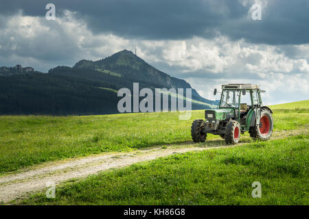 Alten Traktor auf Wiese. schönem Blick auf die Berge in den Alpen Stockfoto