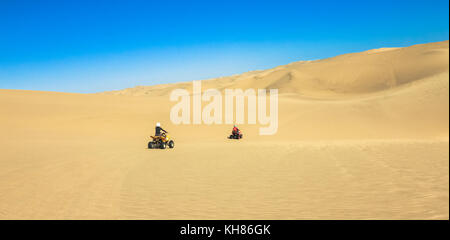 Quad fahren - zwei glückliche Biker im Sand der Wüste. Stockfoto