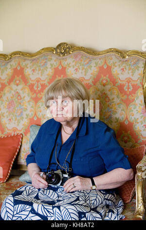 Fotograf Jane Bown (13. März 1925 - 21. Dezember 2014), B&W portrait Sitzen auf einem Sofa holding Kamera Stockfoto