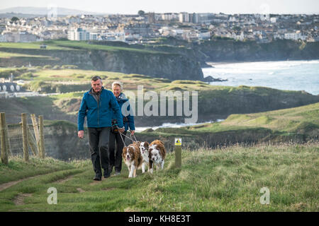 Zwei Leute, die ihre Hunde Haustiere entlang des South West Coast Path in Newquay Cornwall im Vereinigten Königreich. Stockfoto