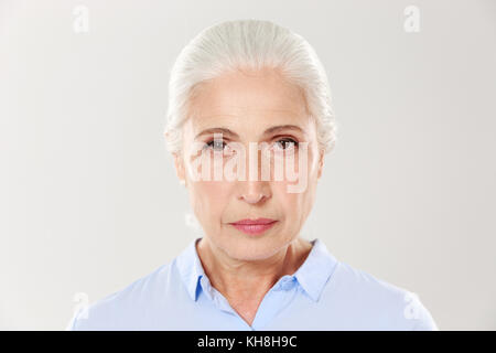 Foto von schweren alten Frau in der Nähe, an der Kamera suchen, auf weißem Hintergrund Stockfoto