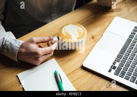7/8-Foto von mans hand in weißem T-Shirt, Tasse Stockfoto