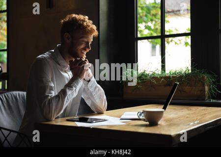 Junge glücklich Abtastkopf bärtiger Mann halten sich an den Händen sitzen zusammen im Café, auf der Suche nach Laptop Bildschirm Stockfoto