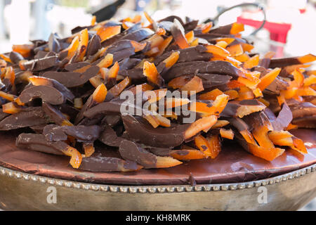 Kandierte Orangenschale bedeckt mit dunkler Schokolade auf Versilberte Schale Stockfoto