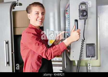 Die Frau als Maschinist arbeitet mit CNC-Maschine in der Metallurgie Factory Stockfoto