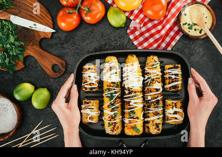 Frau mit Backblech mit maiskolben Stockfoto