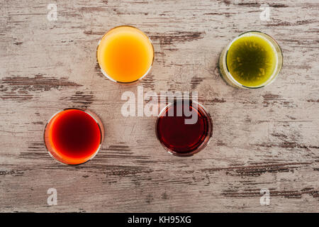 Gläser Saft auf hölzernen Tischplatte Stockfoto