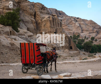 Pferd und Wagen Touristen die Vergangenheit der Obelisk Grab, Bab Al Siq bis zum Eingang des Siq Schlucht, Petra, im frühen Morgenlicht, Jordanien, Naher Osten Stockfoto