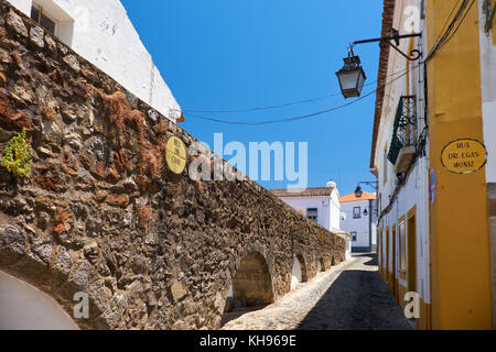 Die Bögen des Aquädukts von Silber Wasser (prata Aquädukt) senkt und sich mit Geschäften und Häusern umgeben, wie sie Portugal Evora eingeben. Stockfoto