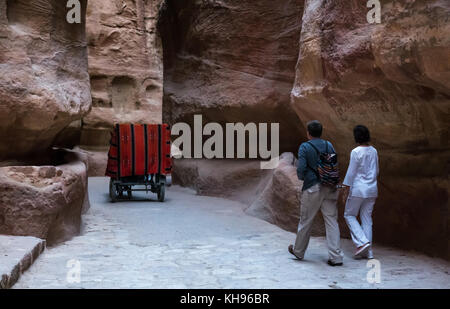 Ein Pferd und Wagen Touristen durch den Siq Schlucht und ein paar wenige, Petra, am frühen Morgen, Jordanien, Naher Osten Stockfoto