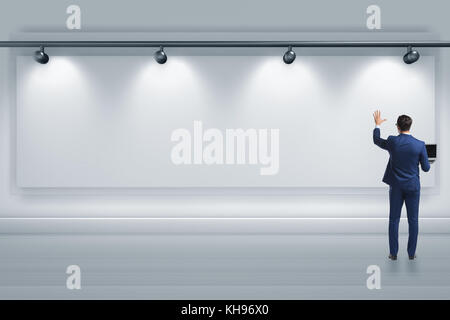 Geschäftsmann drücken virtuelle Taste auf der Wand leuchtet mit Strahlern Stockfoto