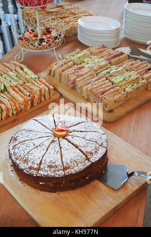 Auswahl an Partyspeisen einschließlich Schokoladenkuchen und Sandwiches - John Gollop Stockfoto