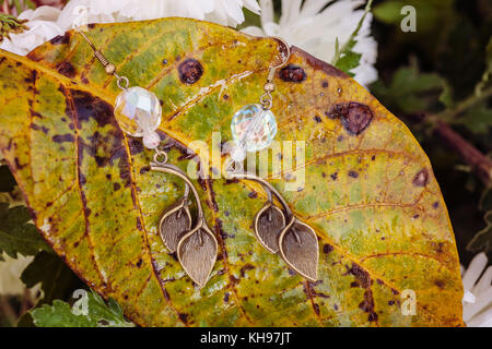 Schöne Ohrringe auf der natürlichen Herbst Hintergrund Stockfoto