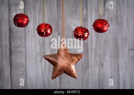 In der Nähe von Weihnachten Sterne und rote Kugeln hängen am Seil gegen Holz- Hintergrund Stockfoto