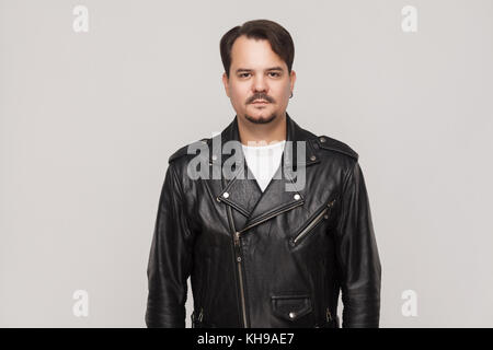 Der Mensch in der Nähe der graue Wand stehen und von der Kamera langweilen. studio Shot Stockfoto