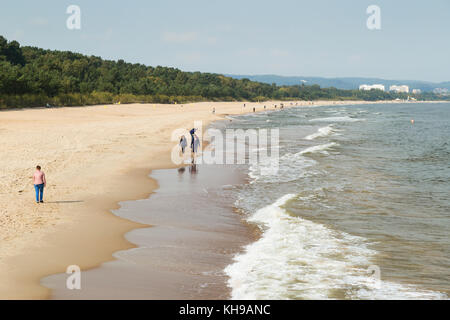 Blick auf wenige Leute an der brzezno Strand und Ostsee in Danzig, Polen flanieren, an einem sonnigen Tag im Herbst. Stockfoto