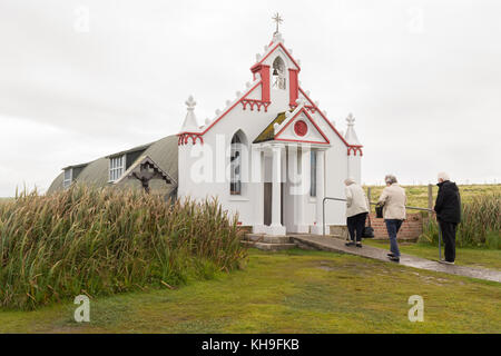 Italienische Kapelle, Lamb Holm, Orkney, Schottland, Großbritannien - Ältere Besucher betreten die kleine Kapelle, die von italienischen Kriegsgefangenen im Zweiten Weltkrieg erbaut wurde Stockfoto